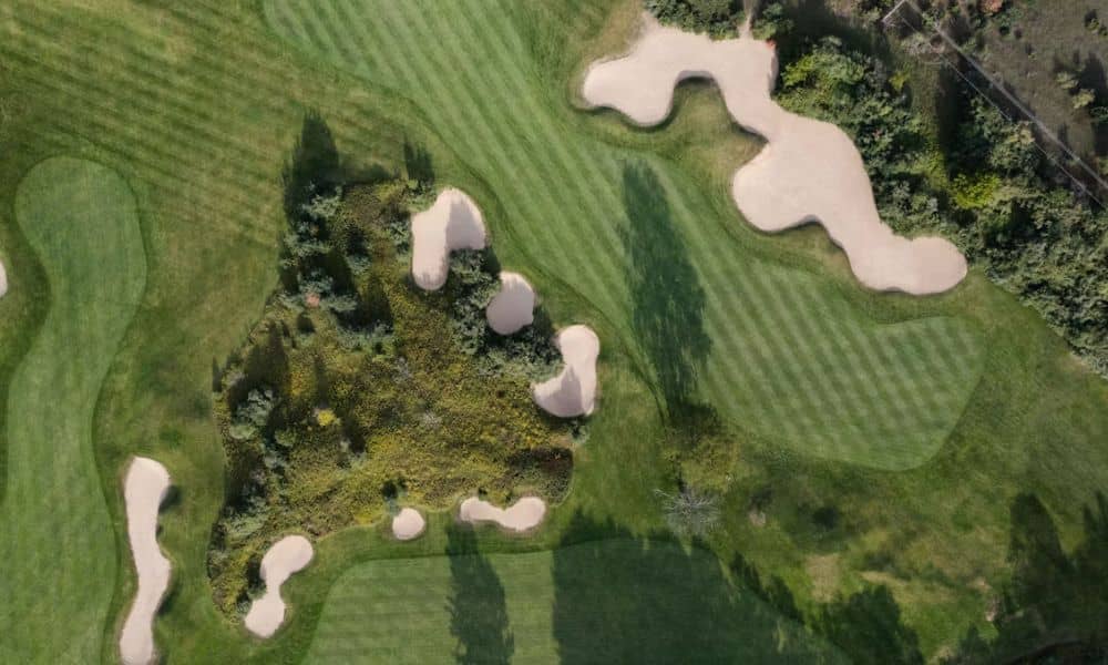 Aerial view of a golf course with fairways, greens, bunkers, and wooded areas that can be mapped through drone surveying for renovation planning