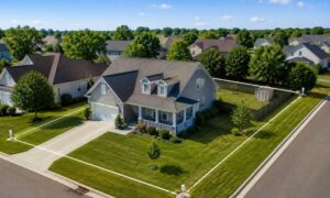 Aerial view of a residential home with property boundary lines illustrating how a mortgage survey confirms the house is located within the legal lot boundaries